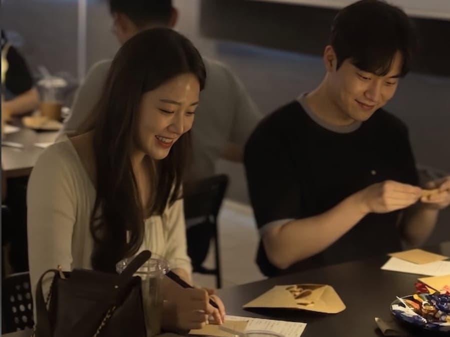 커피와 카드가 놓인 테이블에 나란히 앉은 설레임커피 참여자들