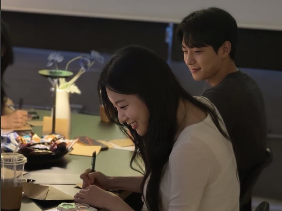 커피잔을 앞에 두고 카드를 적는 설레임커피 참여자