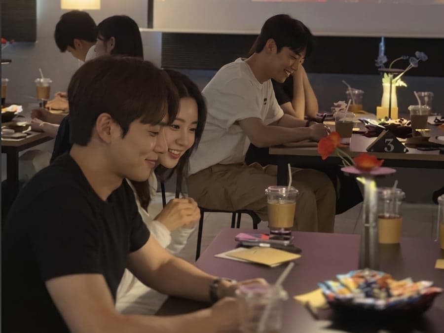 스크린 아래 테이블에 마주 앉아 이야기하는 설레임커피 현장
